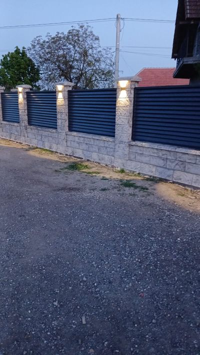 Gard din beton gri cu șipci antracit, văzut din lateral