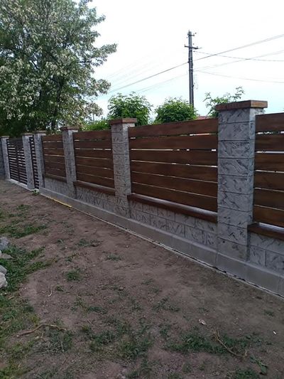 Poartă batantă antracit montată în gard din beton gri