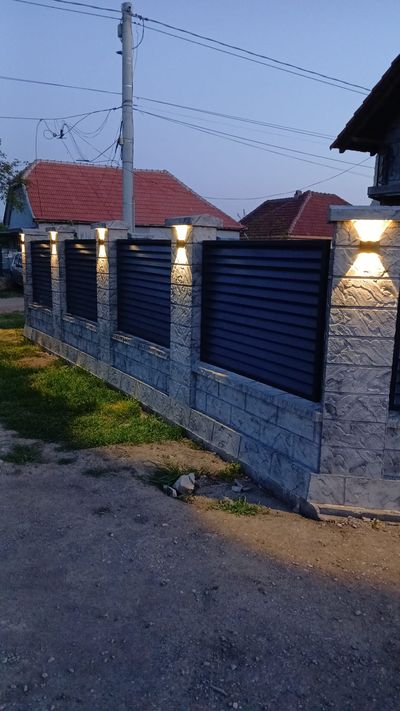 Gard din beton gri cu șipci antracit, lumină de seară