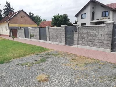 Gard din beton gri cu șipci, văzut din față